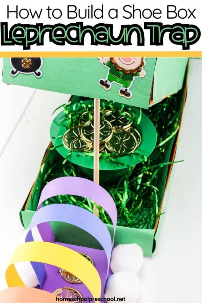 Shoe box leprechaun trap decorated with green paper, gold coins, rainbow paper strips, and shamrocks for a preschool St. Patrick’s Day craft