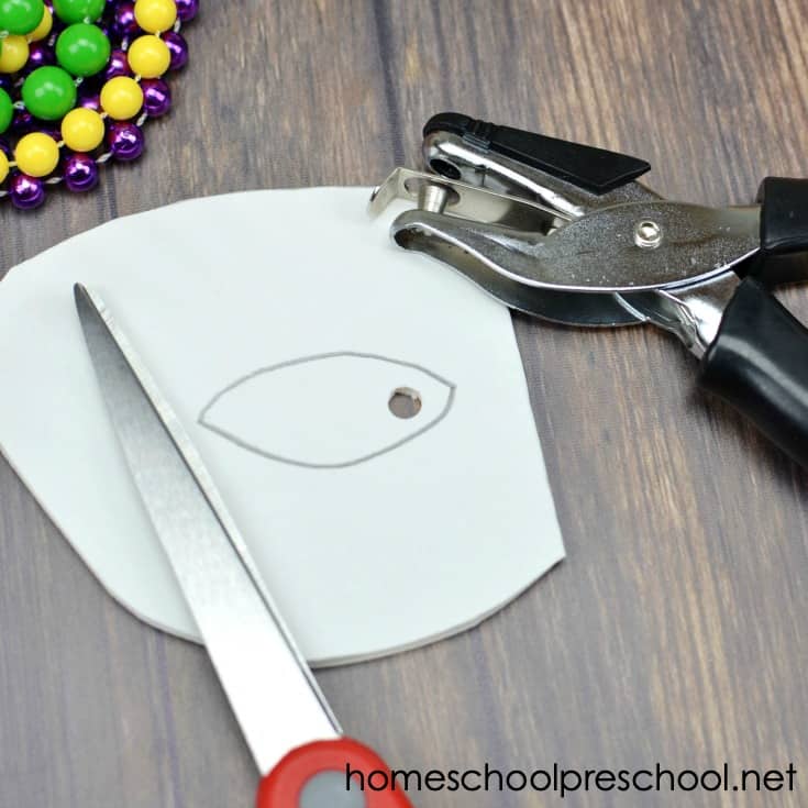 You don't want to miss this festive Mardi Gras paper plate craft for kids! Come see how to turn a paper plate into a fun beaded Mardi Gras mask for kids to wear!