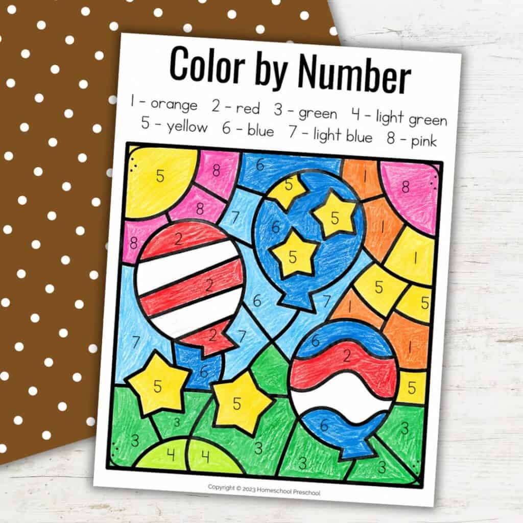 Veterans Day color by number worksheet for preschool and pre-K featuring balloons, stars, and bright crayon-colored sections.