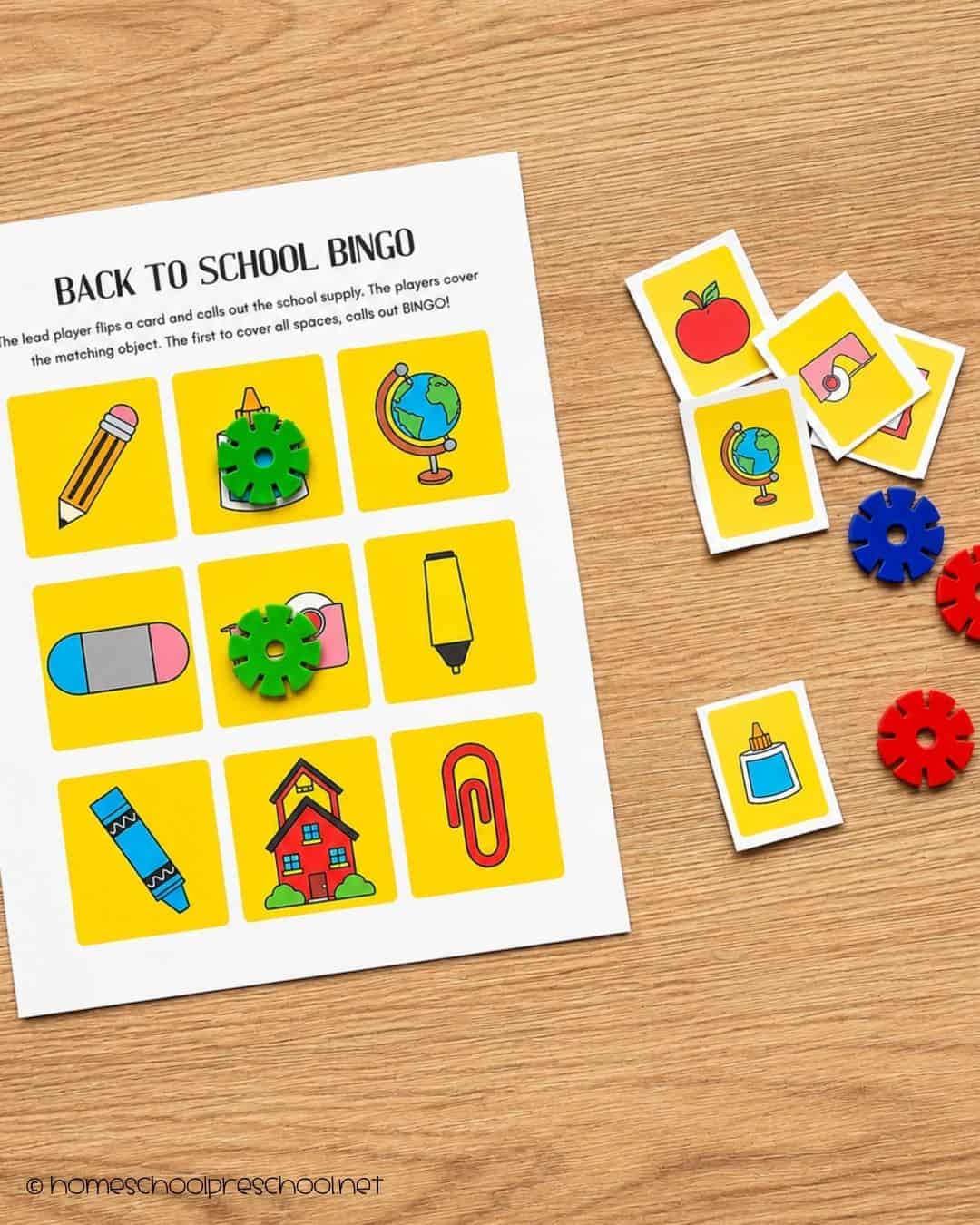 Preschool back-to-school bingo card with matching calling cards and colorful markers featuring school-themed pictures and supplies.