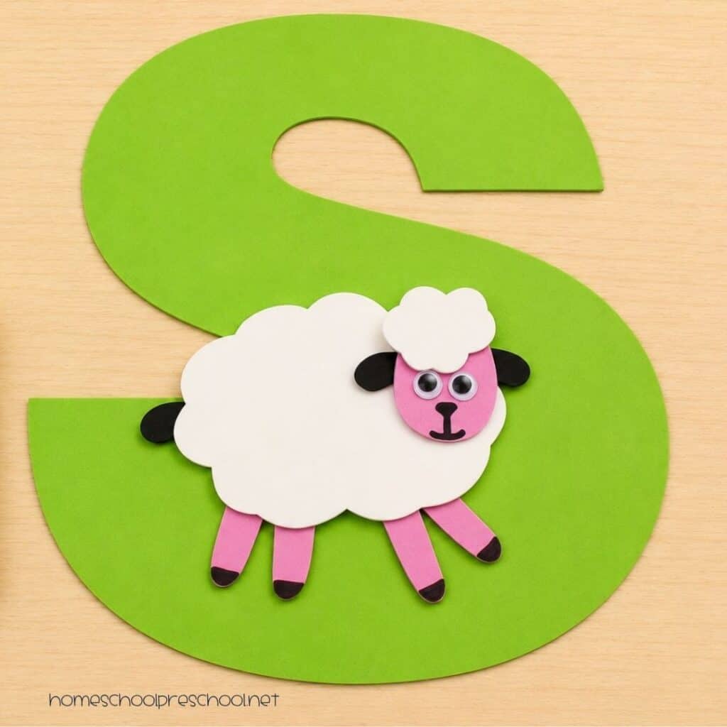 Finished letter S sheep craft featuring a white paper sheep attached to a large green letter S, helping preschoolers practice letter recognition through a hands-on alphabet activity.
