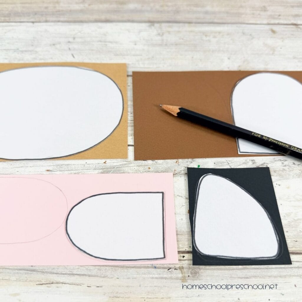 Bear paper plate craft template pieces traced onto colored cardstock before cutting out the ears, muzzle, and nose.