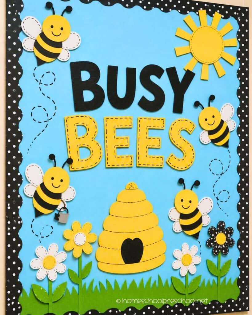 Busy Bees preschool bulletin board with smiling paper bees, a beehive, flowers, sunshine, and the words "Busy Bees."