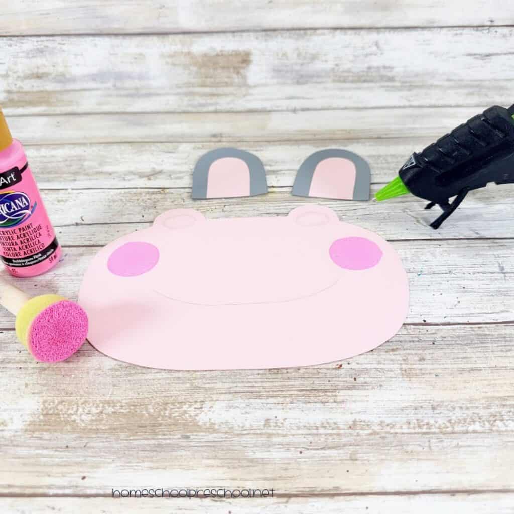 Pink hippo muzzle with painted cheeks and gray and pink ears ready to assemble for a paper plate hippo craft.