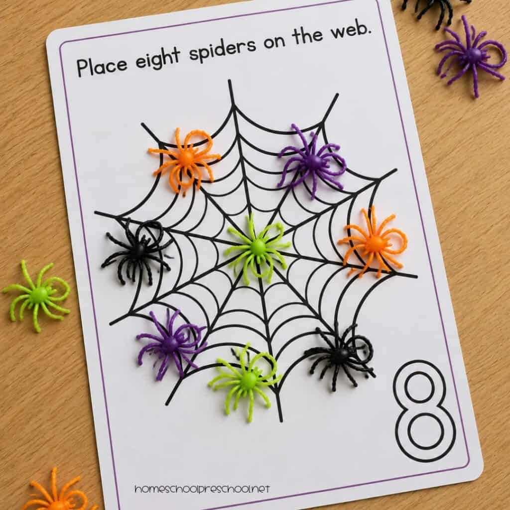 Spider counting mat for number 8 with eight colorful plastic spiders placed on a printable spider web for hands-on preschool counting practice.